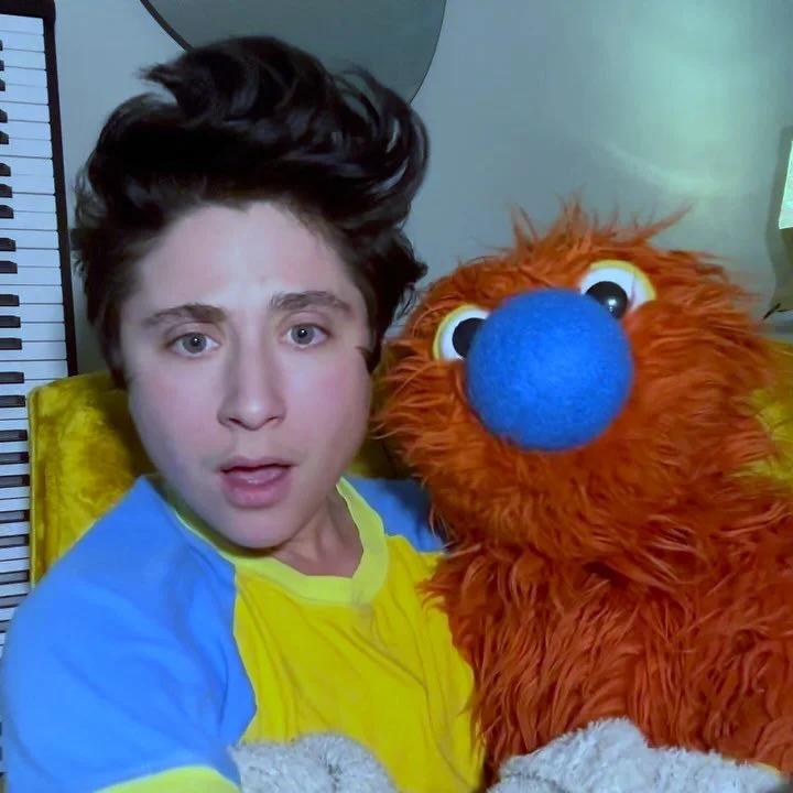 Zack performing with orange and blue puppet Ticklemuff